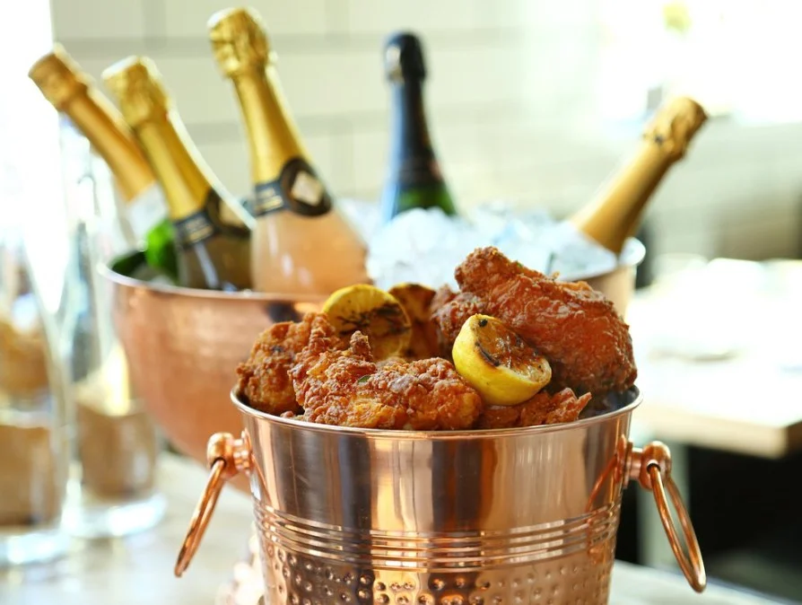 Fried chicken in a copper bucket with Champagne on ice at Liberty Common